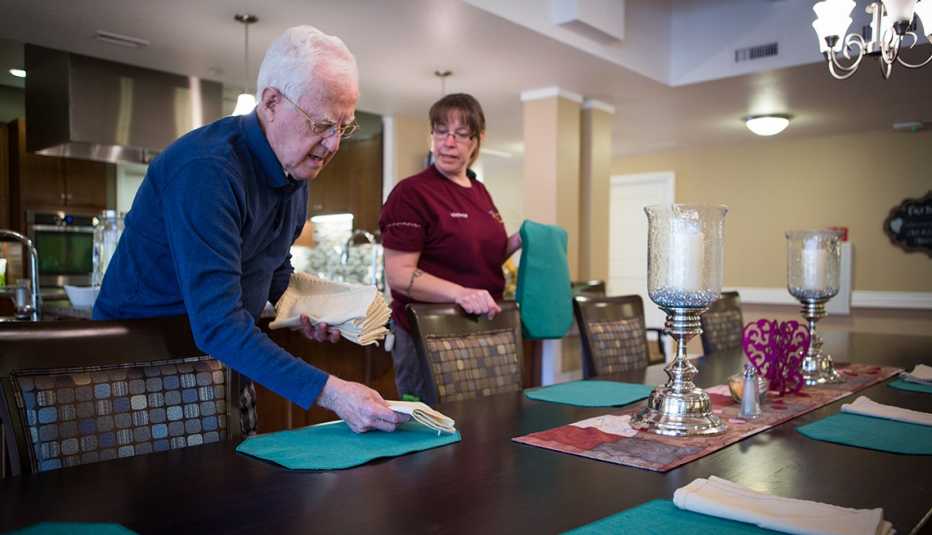 Resident and staff member at the Green House Homes in Colorado setting the table for dinner.