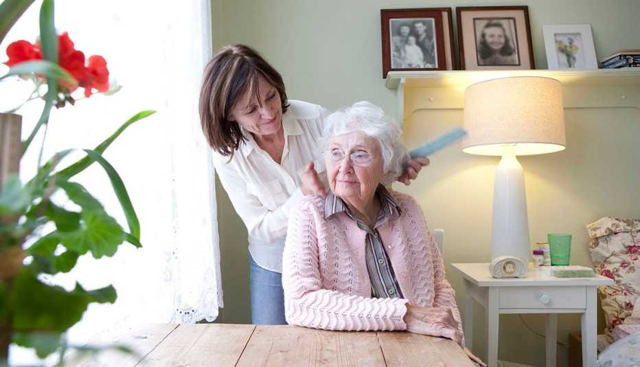 woman combing hair of mother