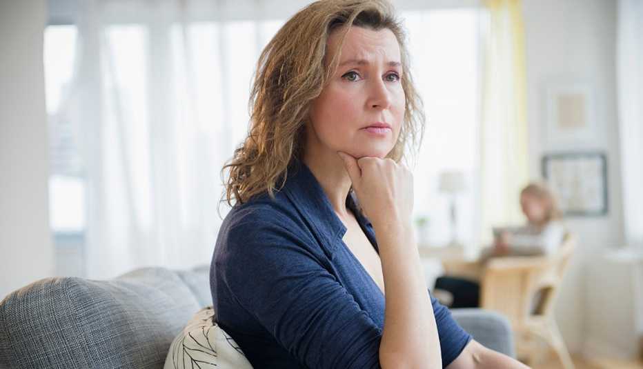 Worried Woman on Couch, Daylight White Curtains, Help for Long-Distance Caregivers Worried Woman on Couch, Daylight White Curtains, Help for Long-Distance Caregivers