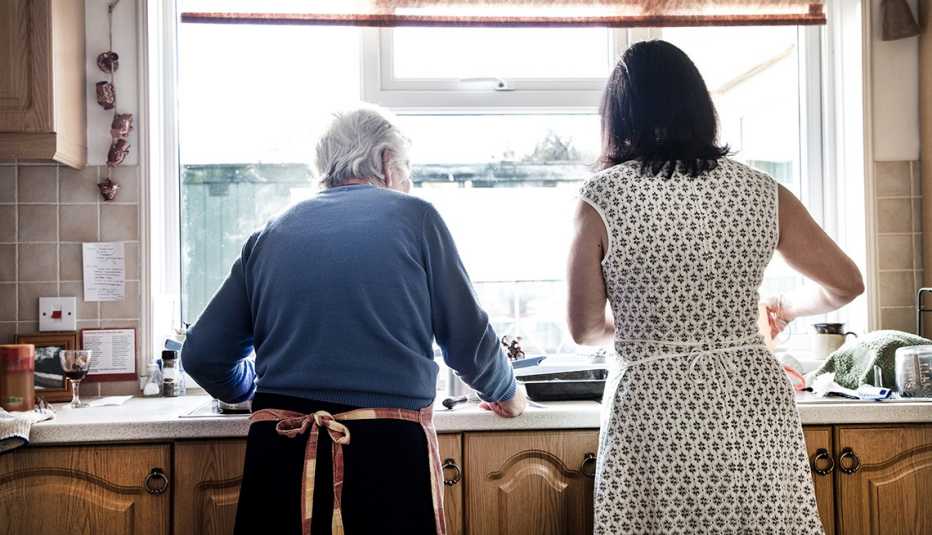 Rear view of a woman and her mother washing dishes together Rear view of a woman and her mother washing dishes together