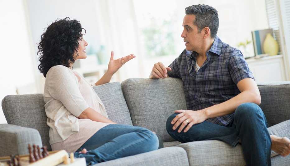 Adult brother and sister sitting on the couch having an argument