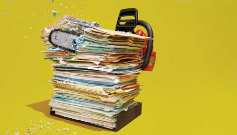 a chainsaw cutting through a tall stack of folders and papers in an inbox