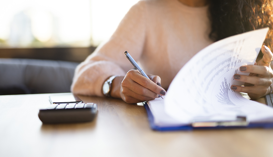woman filling out a form with a calculator