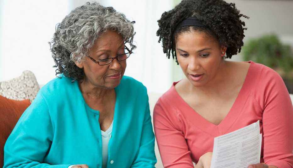 A mother and daughter discussing financial paperwork together