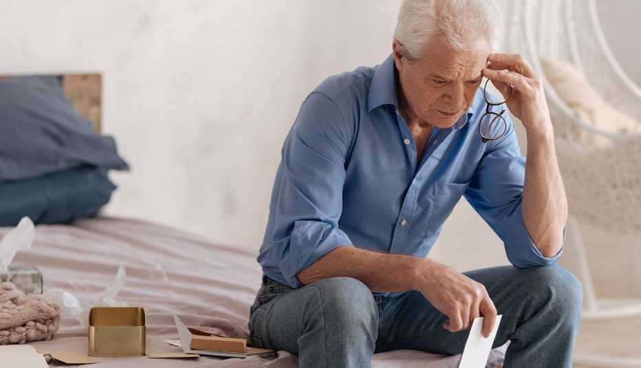 sad man going through a loved ones things after they have died