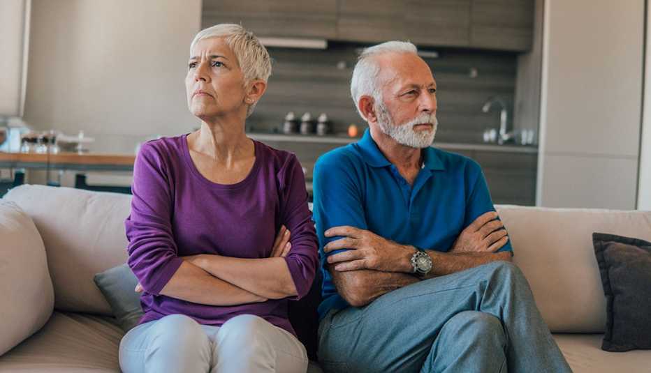 older couple sitting on a couch arguing