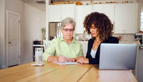 A woman filling out paperwork with a family member. A woman filling out paperwork with a family member.