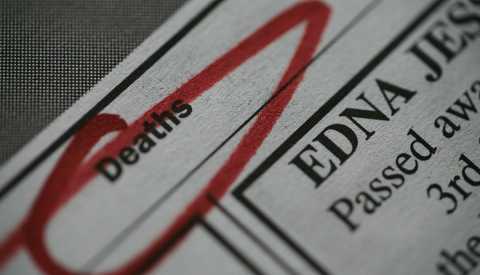 A zoomed in view of a newspaper obituary page with the word death circled A zoomed in view of a newspaper obituary page with the word death circled