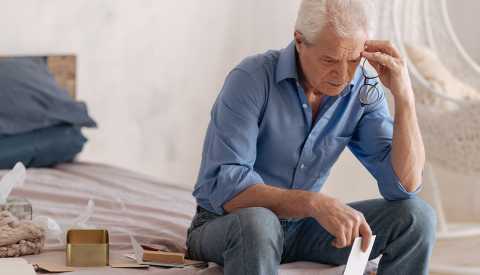 sad man going through a loved ones things after they have died sad man going through a loved ones things after they have died