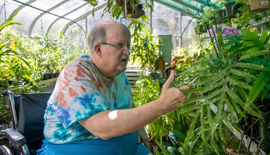 A.G. Rhodes Cobb resident David Waters looks at plants inside the greenhouse at the facility in Marietta, Georgia, USA, Monday, September 26, 2022. A.G. Rhodes Cobb resident David Waters looks at plants inside the greenhouse at the facility in Marietta, Georgia, USA, Monday, September 26, 2022.