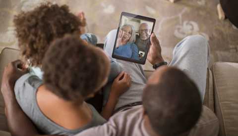 A family having a video call with their older parents
