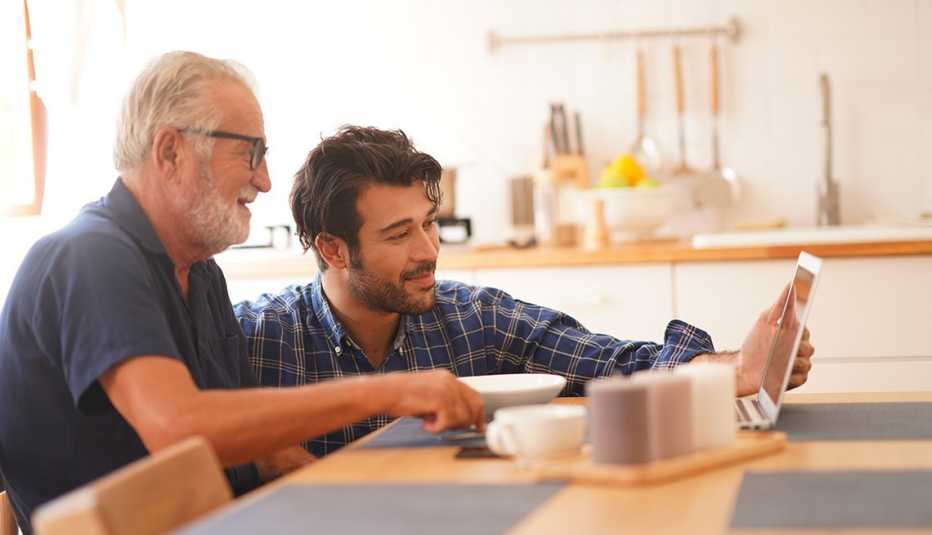 Video calling through laptop computer Young adult son with elderly father make communicate to their family on online app, new normal lifestyle adaptation during lockdown pandemic, stay at home