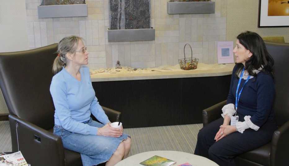 two women sit and talk in a comfortable caregiver center inside a hospital