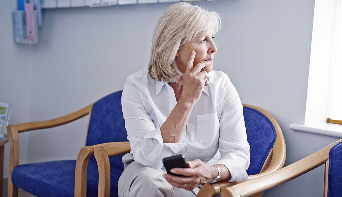 woman on her phone in a hospital seating room