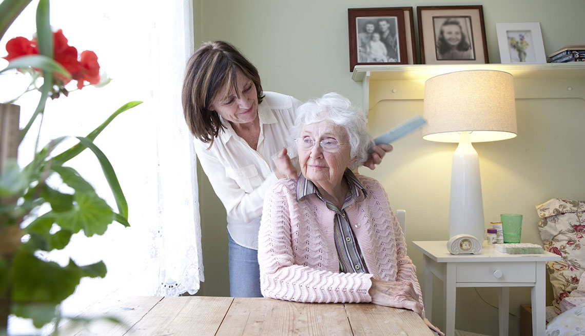 woman combing hair of mother