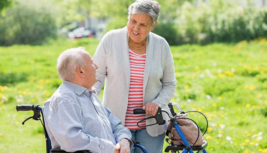 couple with man in wheel chair and his spouse walking