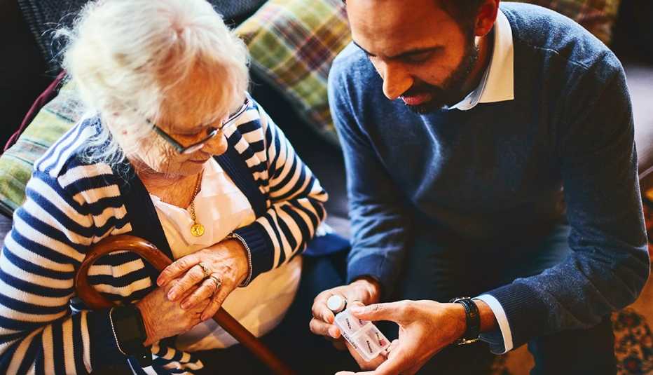 Man explaining medicine dosage to senior female woman.