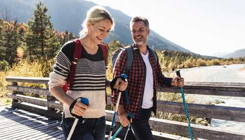 couple hiking across a bridge couple hiking across a bridge