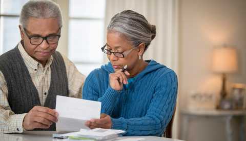 A couple looking through retirement planning paperwork A couple looking through retirement planning paperwork