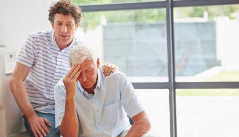 Adult son consoling his upset father Adult son consoling his upset father