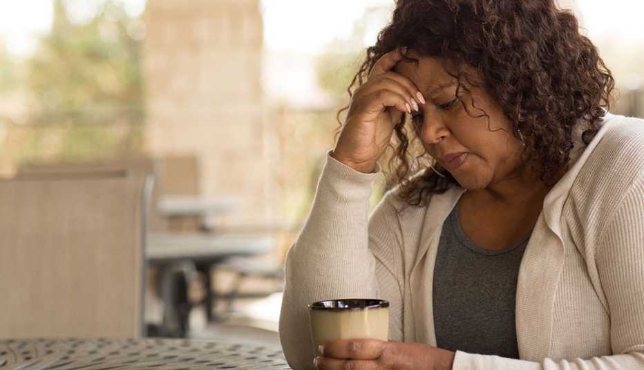 A woman with her hand on her head looking depressed