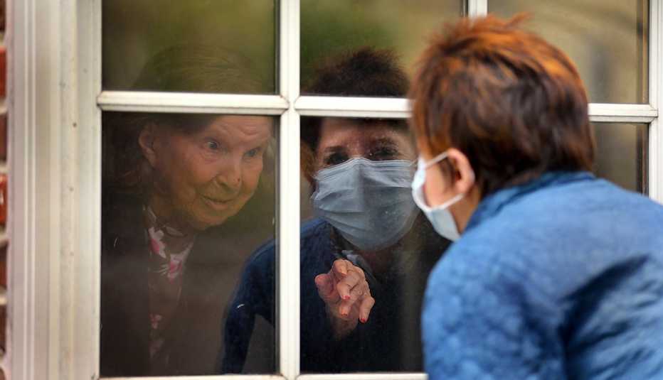 A woman is talking to another woman through a window