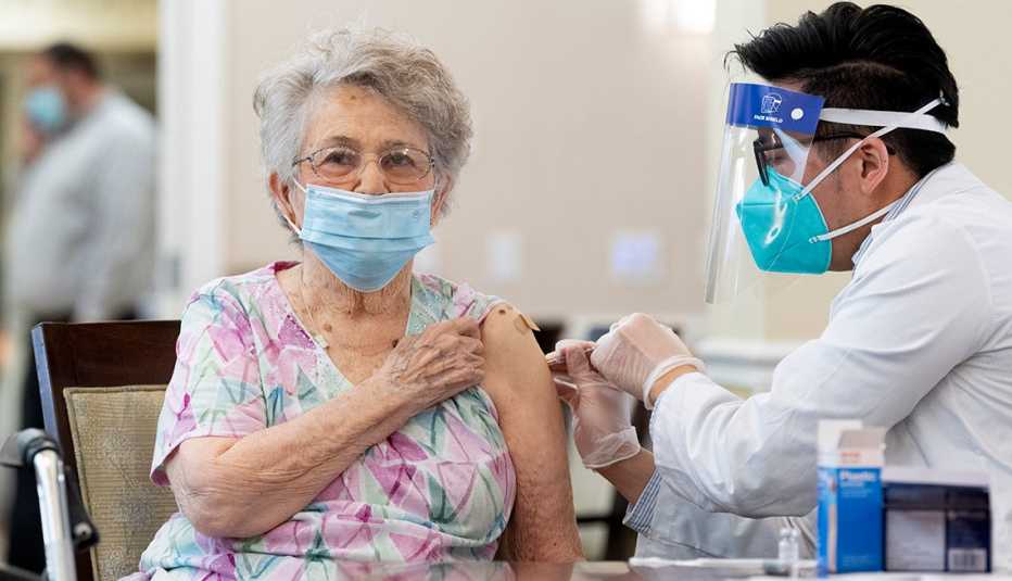 A female nursing home resident getting a covid vaccine shot in the arm