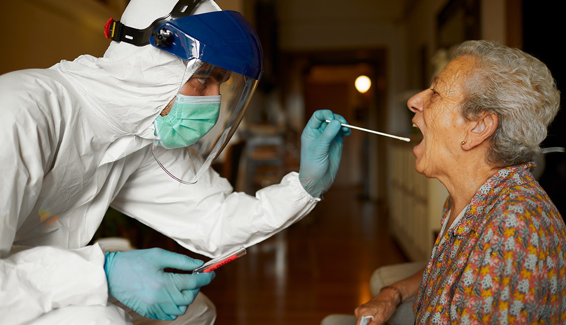 Female nursing home resident getting a covid test from a worker wearing p p e