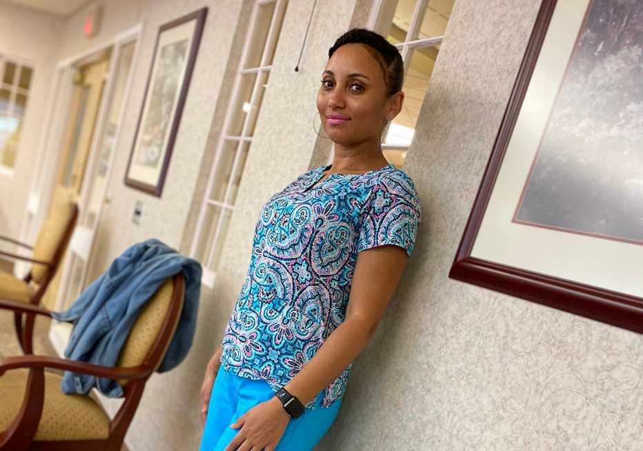 Certified nursing assistant Adelina Ramos standing in the hallway of a nursing home