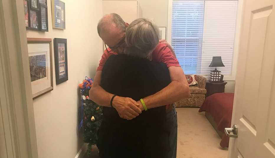 Husband and wife hugging at his nursing home.