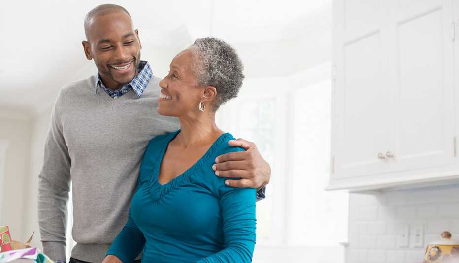 man with her arm around his mother in the kitchen