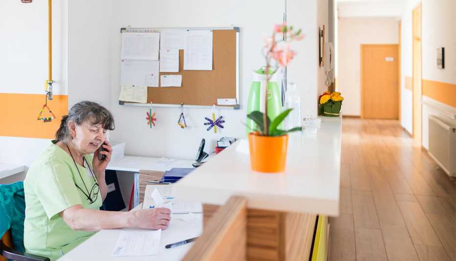 Nurse sitting at desk and answering phone