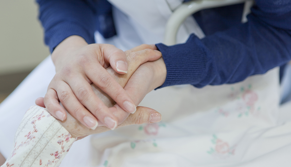 Close up of  a woman holding her mother's had