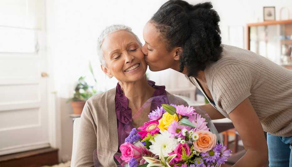 Woman giving mother bouquet of flowers