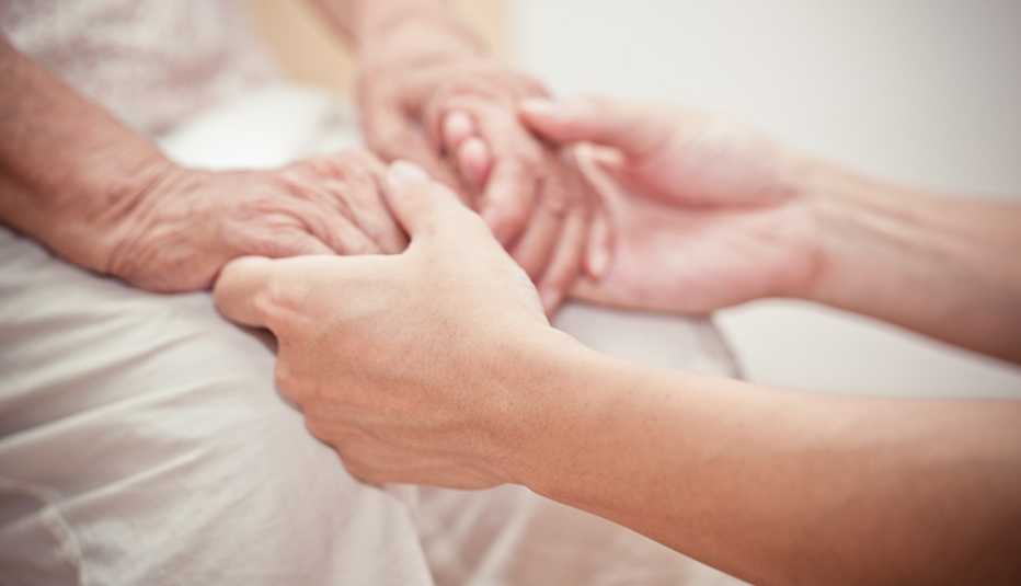 A pair of younger hands holding a pair of older hands