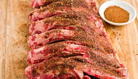 a slab of beef ribs with a bowl of spicy, Texas style dry rub  a slab of beef ribs with a bowl of spicy, Texas style dry rub