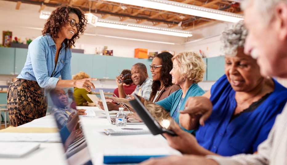 Group Of Retired Seniors Attending IT Class In Community Centre With Teacher