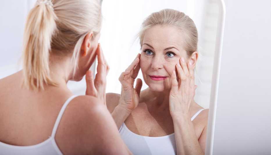 A woman looking at her face in a mirror