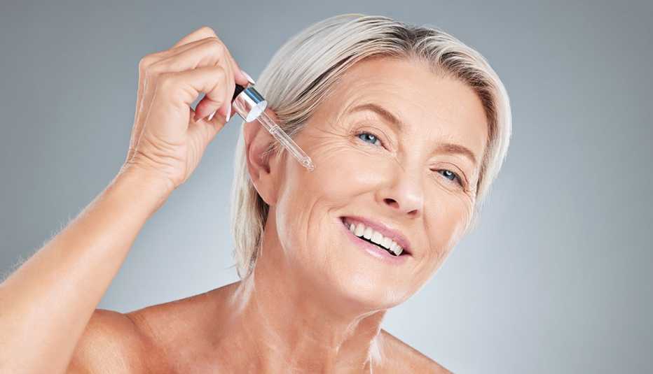 a woman applying facial serum