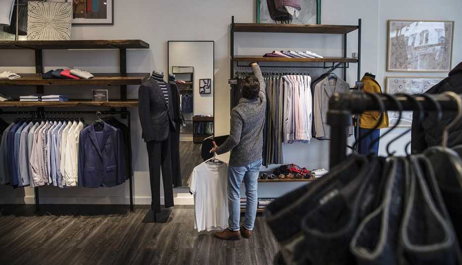 A salesperson arranges clothes in a Bonobos 