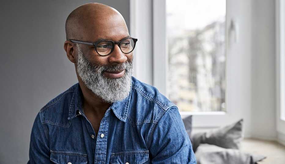 A man smiling while looking out a window