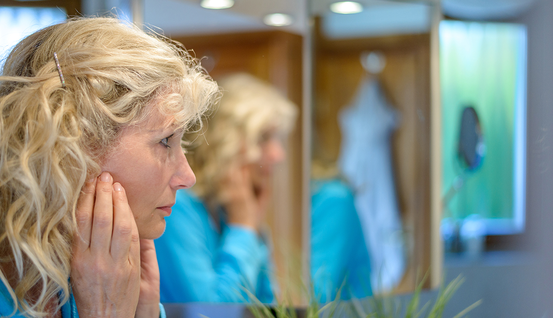 A woman is looking into a mirror