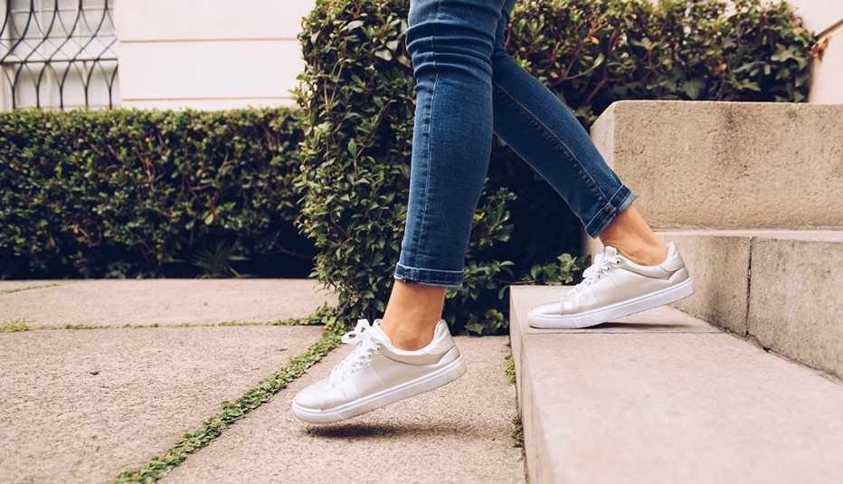 A woman in sneakers walking down stairs
