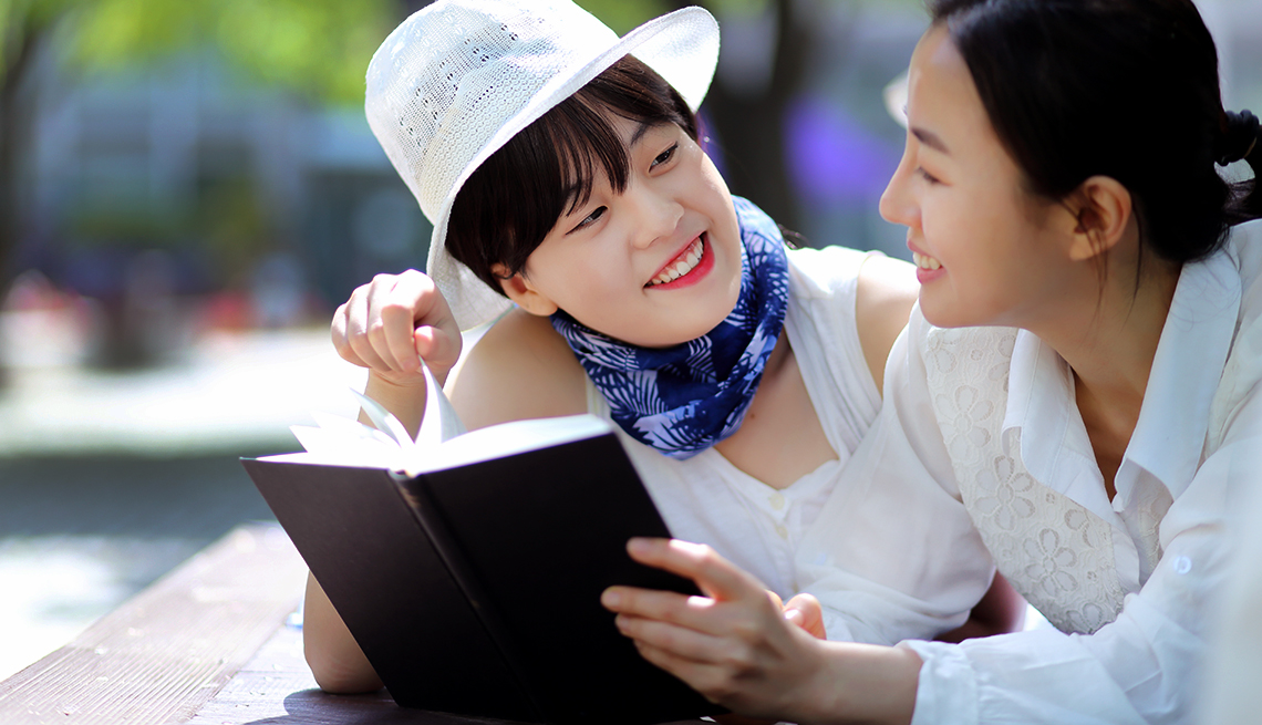 two mature asian women read together 