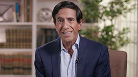 Sanjay Gupta, M.D. smiling in front of a bookshelf
