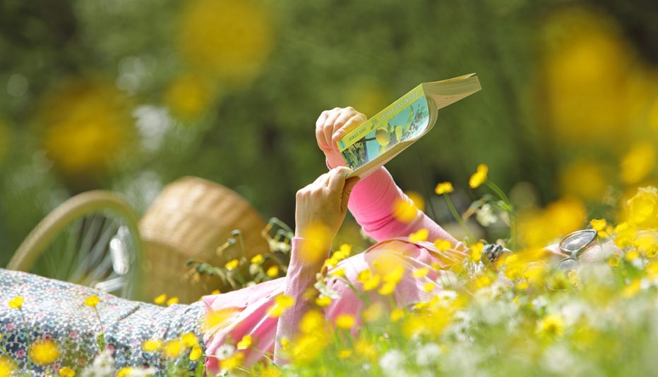 a woman laying in the flowers reading