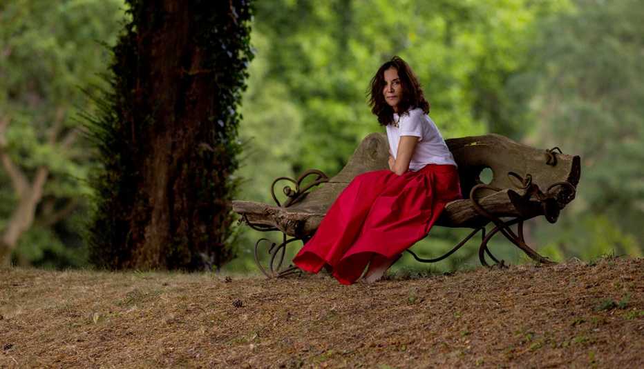 Olivia Harrison sitting on a bench in a wooded area