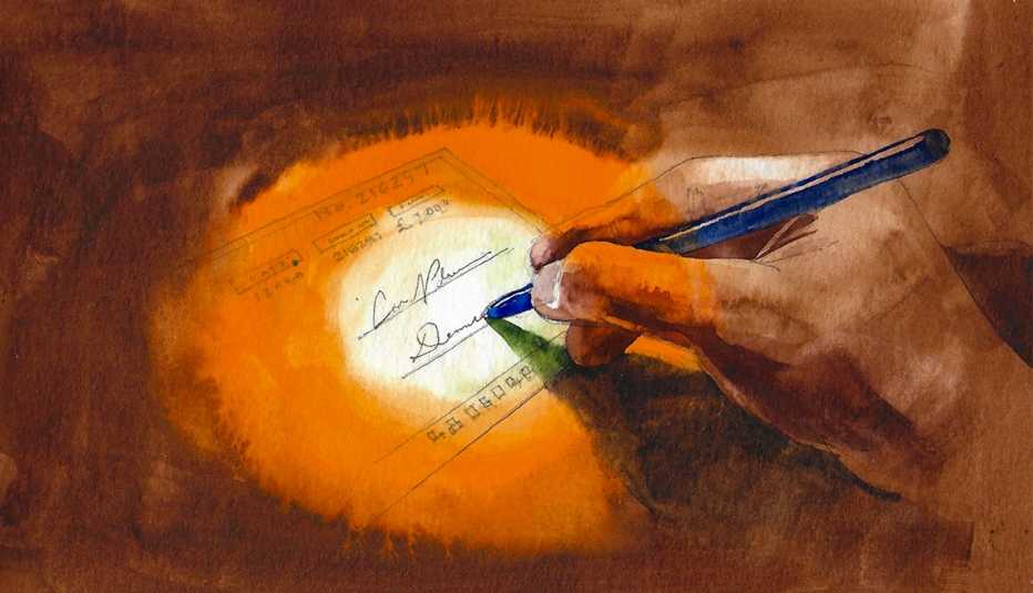 a hand holding a pen signing a check