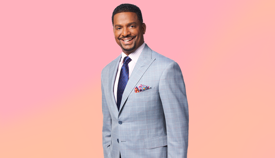 alfonso ribeiro wearing a gray suit and smiling against a light pink and orange background alfonso ribeiro wearing a gray suit and smiling against a light pink and orange background