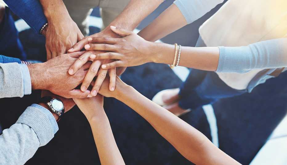 Multi-ethnic group of business people, Huddle, Hands together, Volunteer, AARP Foundation, ElderWatch program